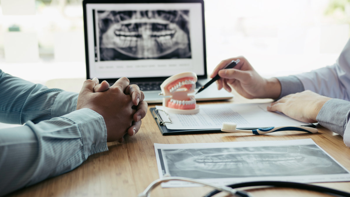 Dental consultation with tooth model and X-rays for inlays and onlays treatment