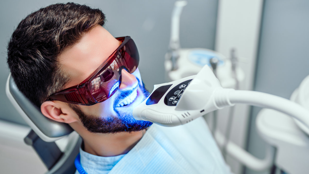 Male dental patient undergoing teeth whitening treatment