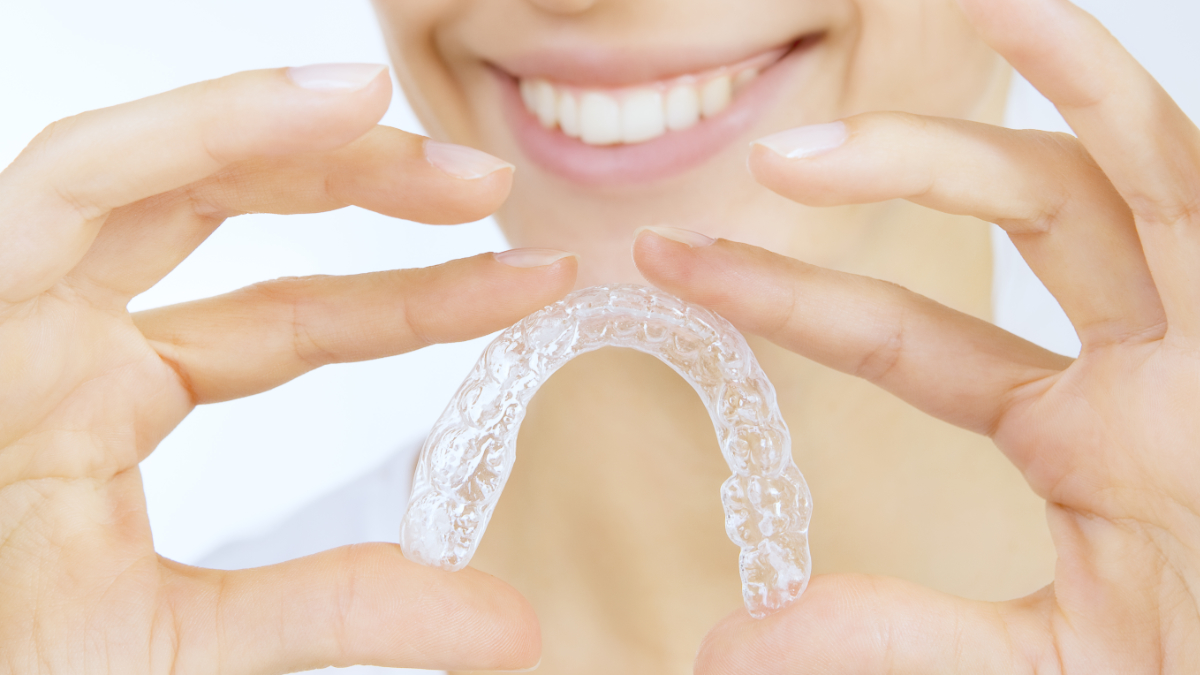 Close-up of woman holding clear aligners